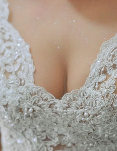 Particolare delle rifiniture in pizzo della scollatura dell'abito da sposa componibile di Sara.