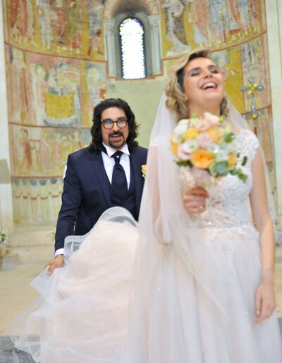 Sposi sorridenti in un momento giocoso all'interno della chiesa di Ronzano